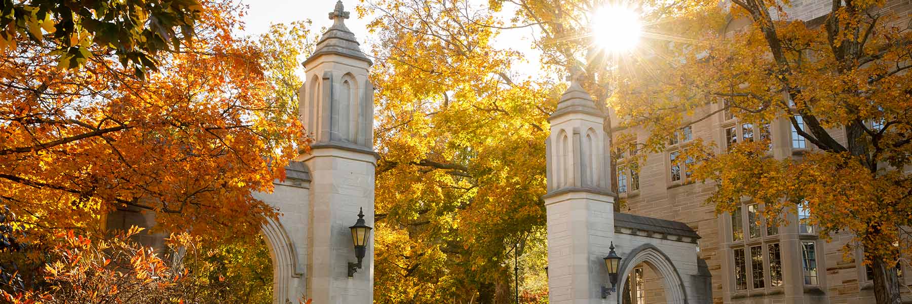 Sunlight streaks past the Sample Gates on a fall day at Indiana University Bloomington.