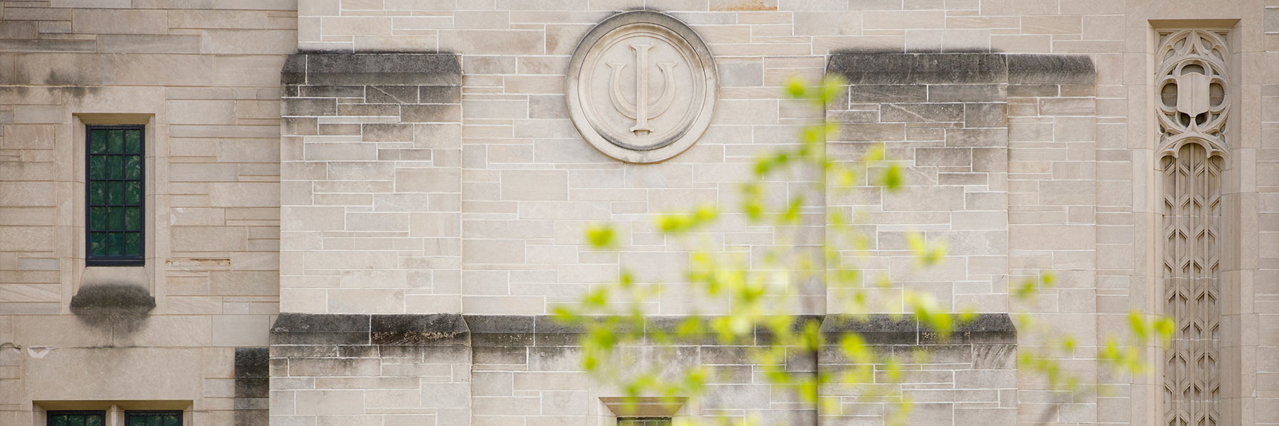An Indiana University trident adorns the side of the IU Auditorium in spring